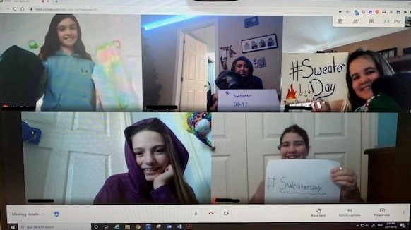 In the photo, students at Holy Rosary Catholic School in Wyoming share their posters to promote the National Sweater Day Challenge, during a virtual meeting.