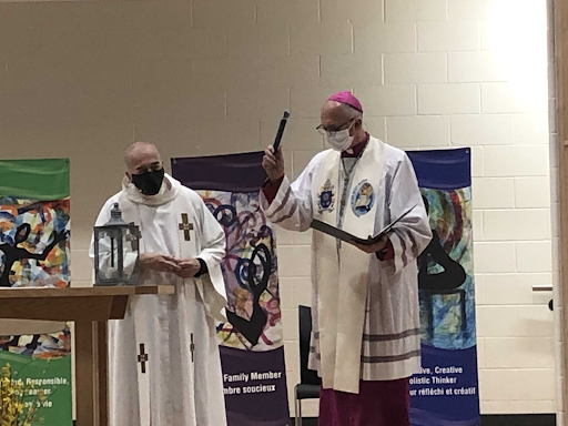 Bishop Joseph Dabrowski, assisted by Father Jim Higgins, leads a virtual service of blessing for St. Angela Merici Catholic School, Chatham